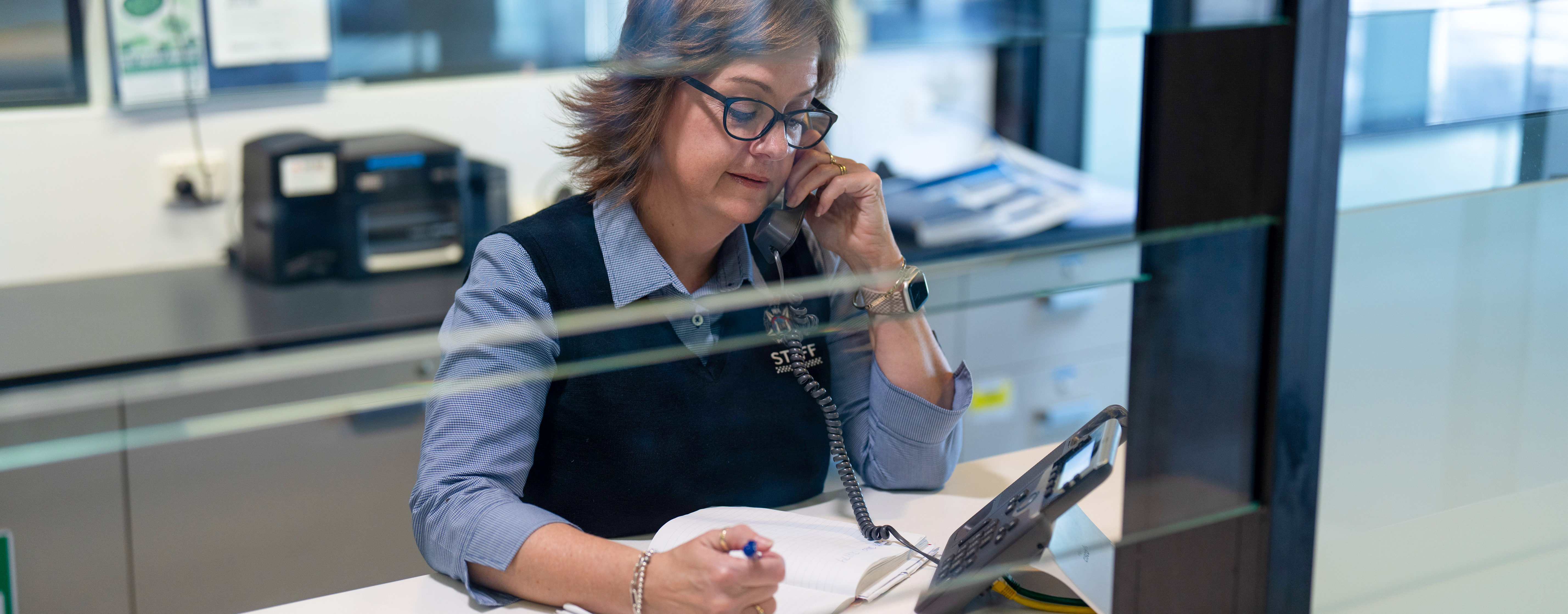 Woman behind a desk on the phone